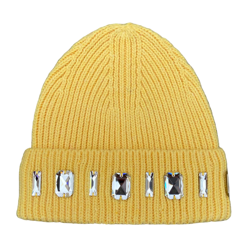 Yellow beanie with decorative gems on a textured surface